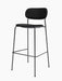 An angled view of the Co Bar Chair, Fully Upholstered, with a black seat and backrest on a slender black steel frame.