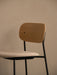Co Bar Chair, Seat Upholstered, close-up showing the natural oak backrest and light upholstered seat on a black frame.