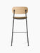 Back view of the Co Bar Chair, Seat Upholstered with a natural oak backrest, bouclé fabric seat, and a black steel frame.