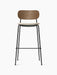 A front view of the Co Bar Chair with a dark stained oak backrest, a cream upholstered seat, and a slender black steel frame.