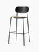 Angled view of the Co Bar Chair with a black oak backrest, beige bouclé upholstered seat, and a slender black steel frame.