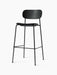 Angled view of the Co Bar Chair, Seat Upholstered, with a black oak backrest, upholstered seat, and black steel frame.
