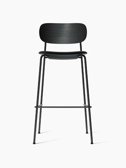 Front view of the Co Bar Chair with a black oak backrest, dark upholstered seat, and slender black steel frame with footrest.