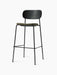A Co Bar Chair with a black oak backrest and a moss green upholstered seat, set on a slender black steel frame.