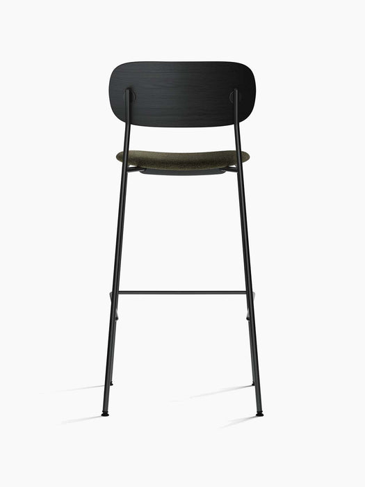Rear view of the Co Bar Chair, Seat Upholstered, showing its black oak back, moss green seat, and slender black steel frame.