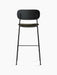 Rear view of the Co Bar Chair, Seat Upholstered, showing its black oak back, moss green seat, and slender black steel frame.