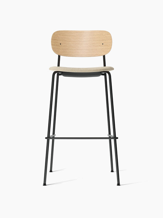 Front view of the Co Bar Chair with a natural oak backrest, cream bouclé upholstered seat, and a slender black steel frame.