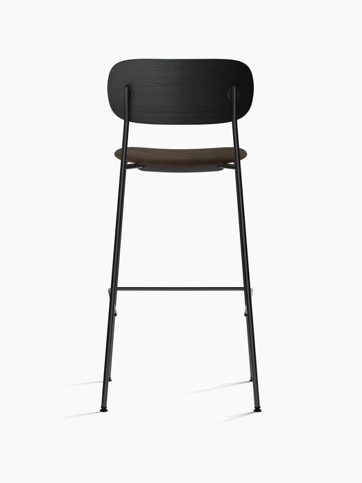 Rear view of the Co Bar Chair, Seat Upholstered, with a black oak backrest, brown upholstered seat, and black steel frame.