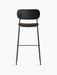 Rear view of the Co Bar Chair, Seat Upholstered, with a black oak backrest, brown upholstered seat, and black steel frame.
