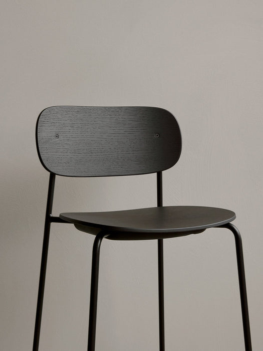 A close-up of the Co Bar Chair in black oak veneer, showing the detail of the wood grain on the backrest and seat.