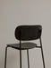Rear close-up of the Co Bar Chair in dark stained oak veneer, focusing on the textured backrest and slim black metal frame.