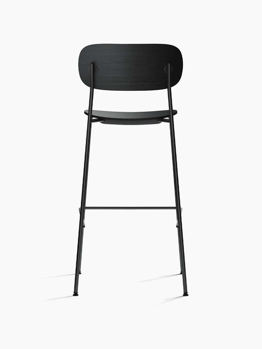 Rear view of the black oak veneer Co Bar Chair, with its wide backrest and slender black steel frame on a white background.
