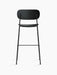 Rear view of the black oak veneer Co Bar Chair, with its wide backrest and slender black steel frame on a white background.