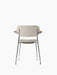 Back of a fully upholstered Co Dining Chair with armrests. It has light fabric, natural oak armrests and a chrome frame.