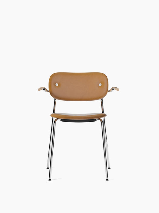 Front view of the Co Dining Chair, fully upholstered in light brown Dakar leather with natural oak armrests and chrome frame.
