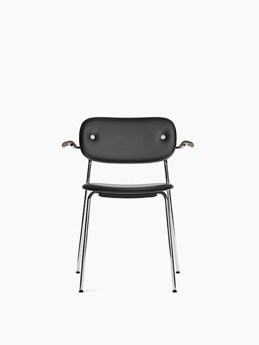 Front view of Co Dining Chair. Features black Dakar leather upholstery, dark stained oak armrests, and polished chrome frame.