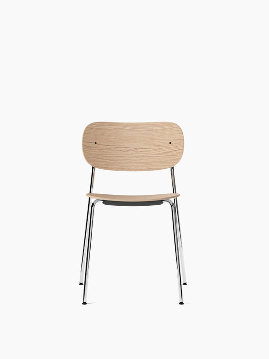 Front view of the Co Dining Chair, featuring a natural oak veneer seat and backrest on a slender, polished chrome frame.