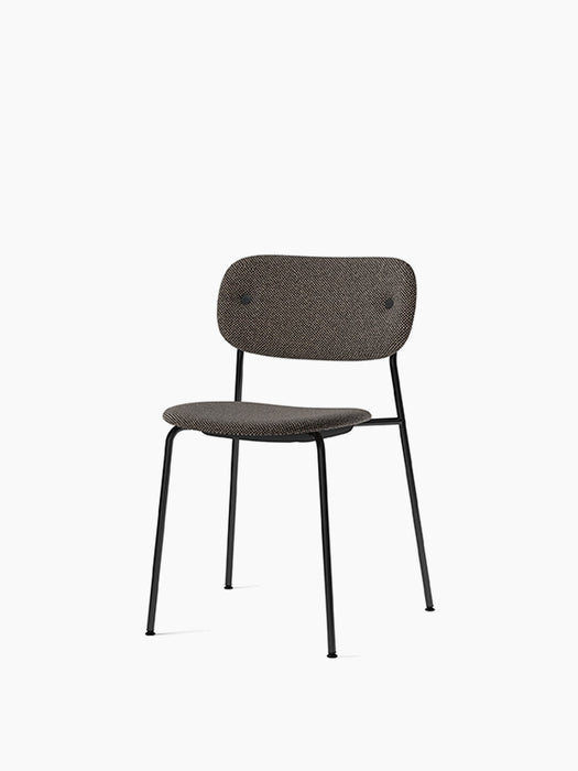 Angled view of the Co Dining Chair, fully upholstered in dark, textured Doppiopanama fabric with a slender black steel frame.