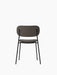 A back view of the Co Dining Chair. It is fully upholstered in a dark, textured fabric and has a slim, black metal frame.