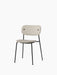 Co Dining Chair, fully upholstered in a light beige textured fabric with a slim black frame, shown at a three-quarter angle