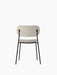 Rear view of the fully upholstered Co Dining Chair in Black, showing its light beige fabric and slender black steel frame.