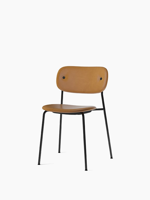 Front-angle view of the Co Dining Chair with tan leather upholstered seat and backrest on a slim black steel frame.
