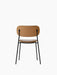 Back view of the Co Dining Chair, fully upholstered in tan Dakar leather with a slender, black powder-coated steel frame.