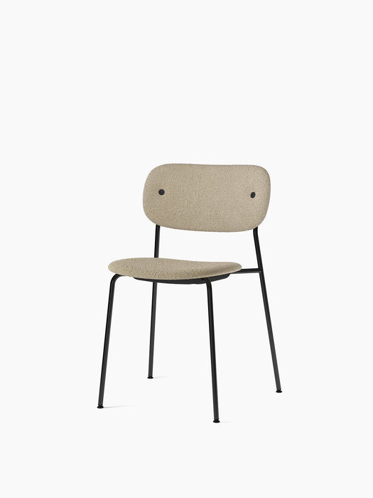Angled view of the Co Dining Chair, fully upholstered in Audo Bouclé 02 fabric with a slim, black powder-coated steel frame.