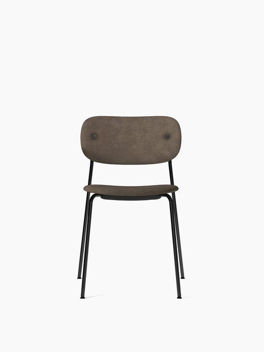 A front view of the Co Dining Chair, featuring a fully upholstered brown seat and backrest on a slim, black steel frame.