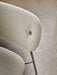 A detailed close-up of the fully upholstered Co Dining Chair, showing the textured cream Audo Bouclé fabric and chrome legs.