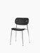 Angled view of the Co Dining Chair with a fully upholstered black seat and backrest on a slim, four-legged chrome frame