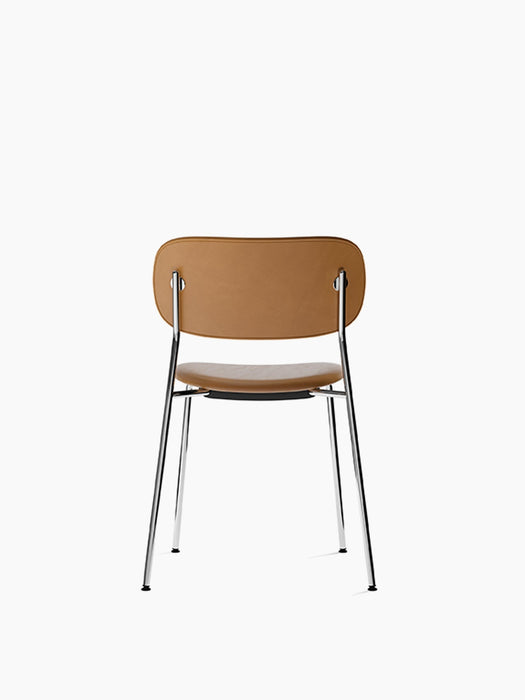 Back view of the Co Dining Chair, fully upholstered in tan Dakar leather with a slender, supportive chrome frame.