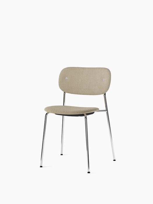 Co Dining Chair with a chrome frame, fully upholstered in a textured, light beige bouclé fabric, shown at an angle.