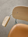 Close-up of the Co Dining Chair with armrest, showing the natural oak veneer back, chrome frame, and tan upholstered seat.