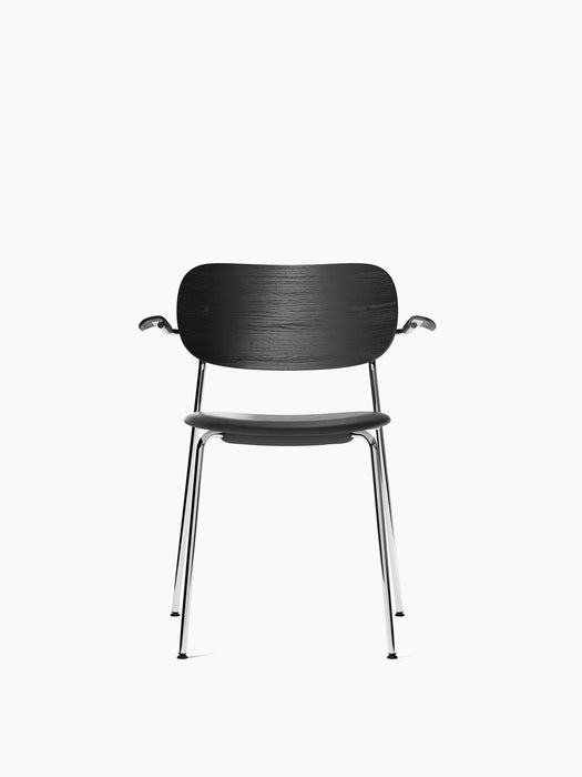 Front view of the Co Dining Chair with armrests, shown with a black oak back, black upholstered seat, and chrome legs.