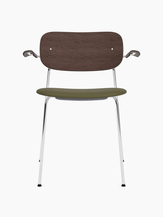 A Co Dining Chair with armrests, front view. Features a dark stained oak back, an olive green seat, and a chrome frame.