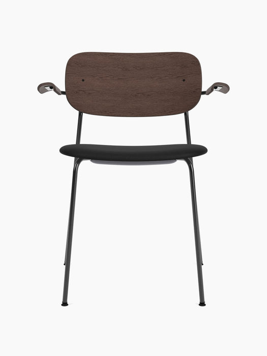 Front view of Co Dining Chair with black frame, black upholstered seat, dark stained oak veneer backrest and armrests.