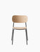A Co Dining Chair with a natural oak veneer seat and backrest is shown from the front. It has a slender black steel frame.
