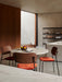 Four Co Dining Chairs with orange seats around a marble Column Table in a dining room with concrete walls and a Zet shelf.