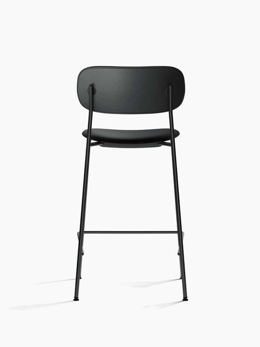 Back view of the Co Counter Chair, fully upholstered in black Dakar leather with a slender, black powder-coated steel frame