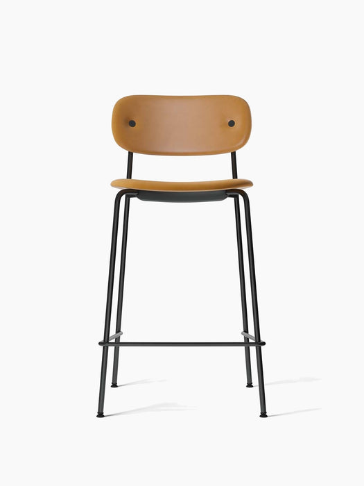 Front view of the Co Counter Chair, Fully Upholstered with a tan leather seat and backrest on a slender, black steel frame.