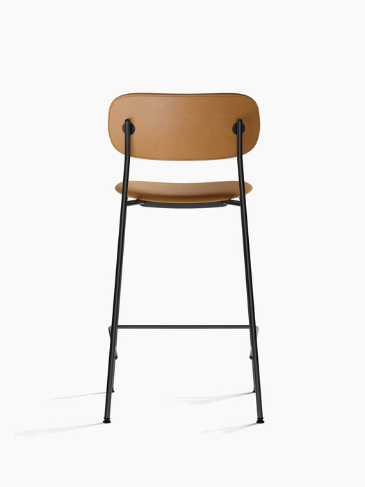 Back view of the Co Counter Chair, Fully Upholstered, in tan leather with a slender black powder-coated steel frame.