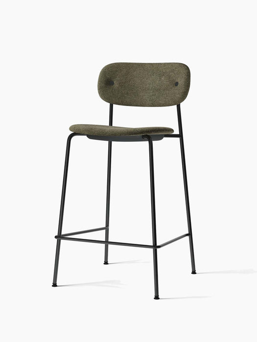 An angled view of the Co Counter Chair, Fully Upholstered. Moss green textured seat and back on a black metal frame.
