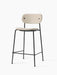 A Co Counter Chair, Fully Upholstered, with a black steel frame and a light-coloured textured fabric on the seat and back.