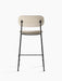 Back view of the Co Counter Chair, Fully Upholstered, showing its light beige fabric seat and backrest and black metal frame.