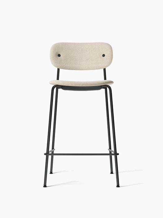 Front view of the Co Counter Chair, Fully Upholstered. The chair has a slim black metal frame and light beige upholstery.