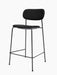 A fully upholstered Co Counter Chair in black fabric with a black powder-coated steel frame, shown at an angle.