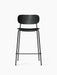 The Co Counter Chair in black oak with a black leather upholstered seat and a black steel frame, viewed from the front.