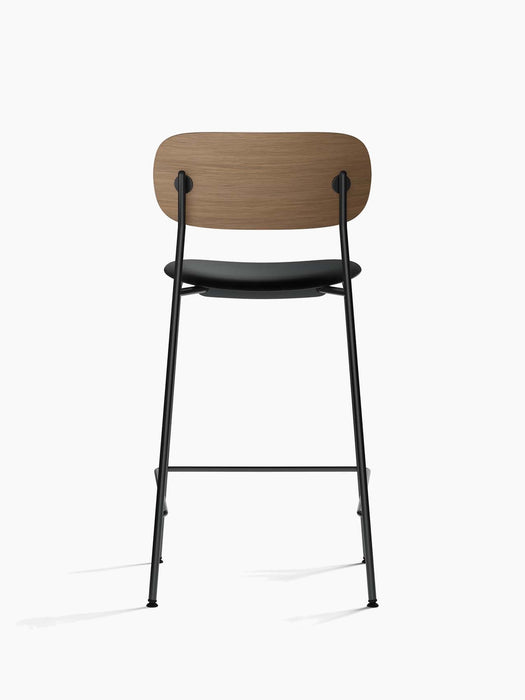 Back view of the Co Counter Chair with a dark stained oak backrest, black upholstered seat and slender black steel frame.