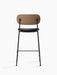 Back view of the Co Counter Chair with a dark stained oak backrest, black upholstered seat and slender black steel frame.